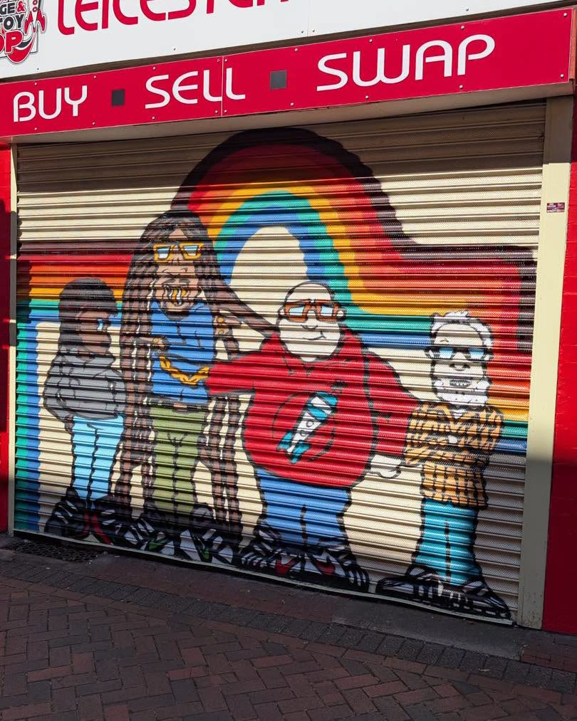 Colourful painted shop shutter mural with cartoon characters and rainbow